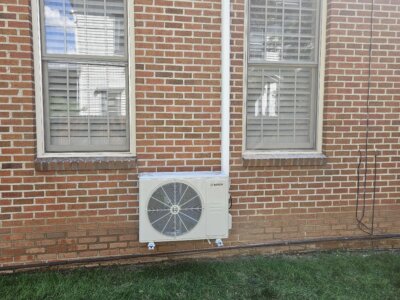 A picture of a mini split air conditioning unit outside of a home.