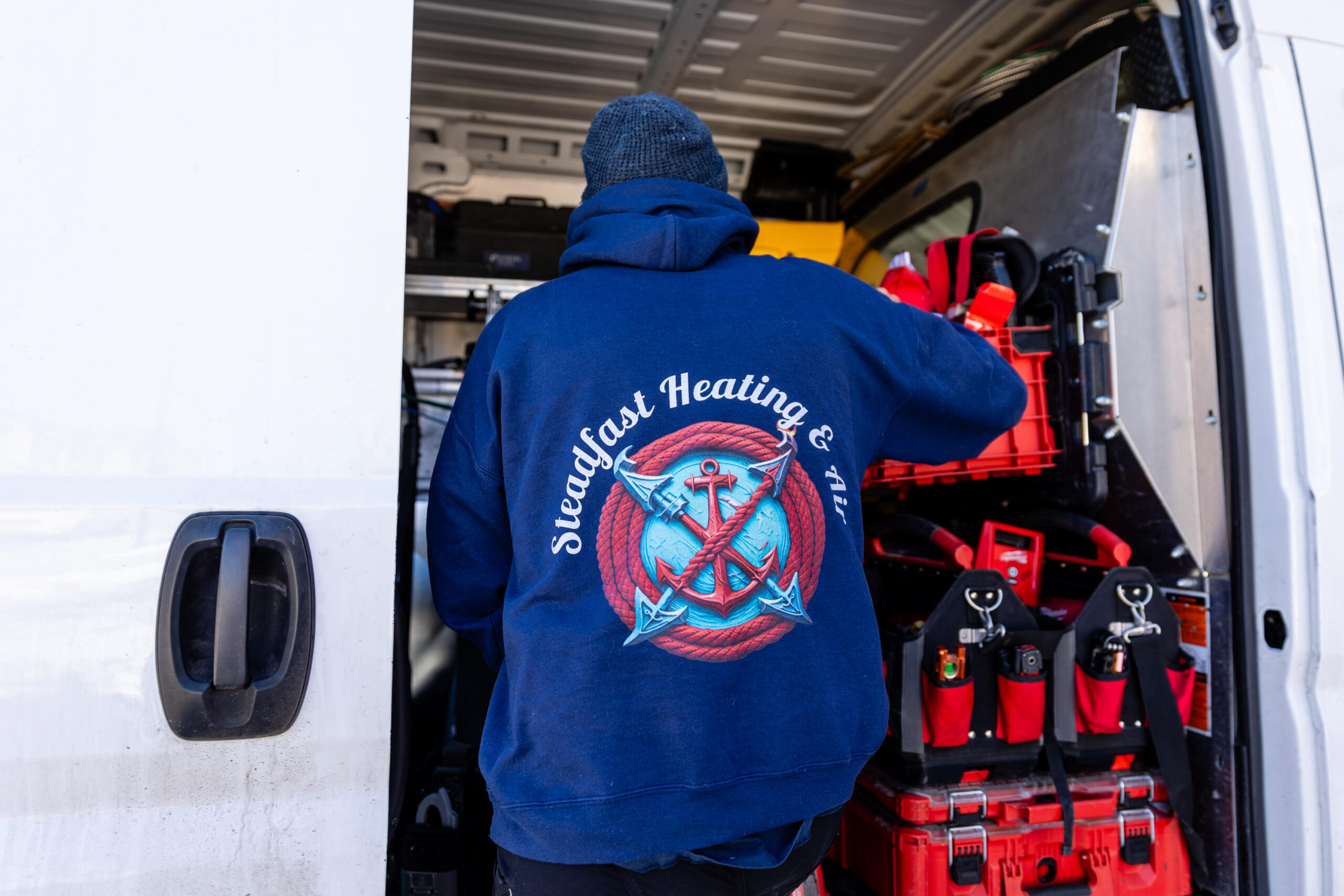 HVAC technician gathering equipment from a service vehicle