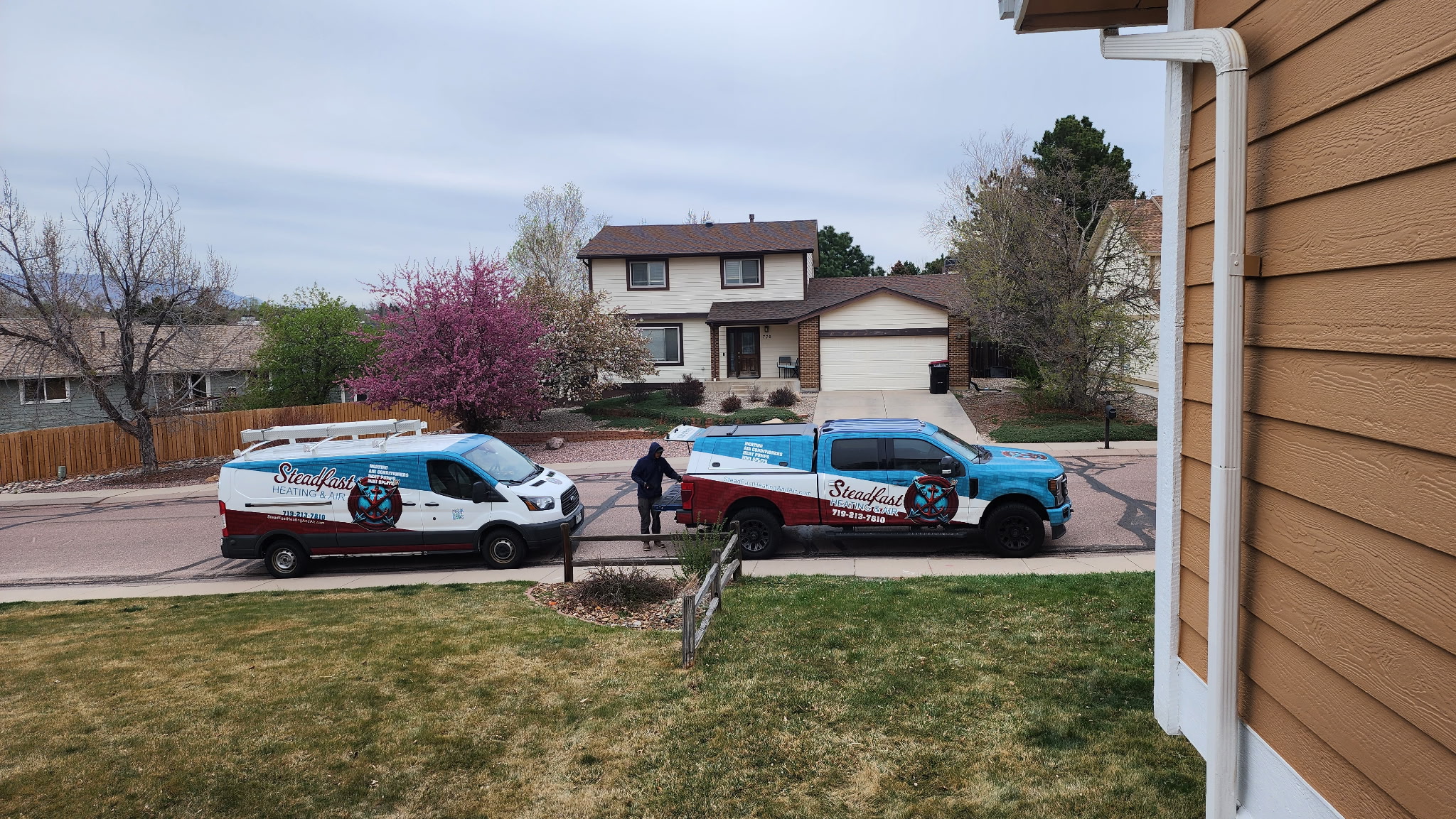 Steadfast Heating & Air service vehicles at a home